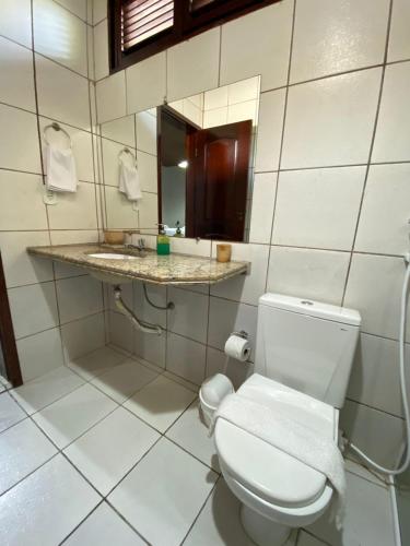 a bathroom with a white toilet and a sink at Pousada Sitio Parque dos Lençóis in Barreirinhas