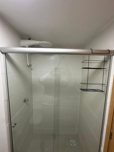 a shower with a glass door in a bathroom at Studio Central Independência 915 in Juiz de Fora