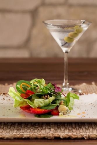 a plate with a salad and a glass of wine at Allegretto Vineyard Resort Paso Robles in Paso Robles