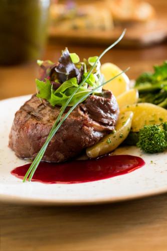 a plate of steak and vegetables on a table at Allegretto Vineyard Resort Paso Robles in Paso Robles