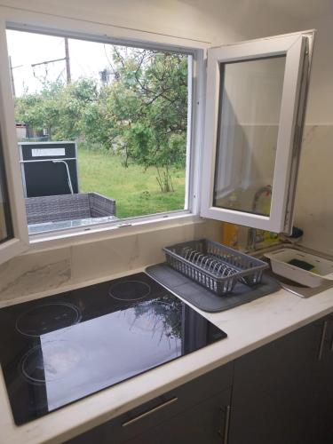 Il comprend une cuisine équipée d'un évier, d'une fenêtre et d'une cuisinière. dans l'établissement Chez Nour, à Dammarie-les-Lys