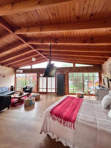 a bedroom with a large bed and a living room at alojamiento Lof tüng in Los Vilos