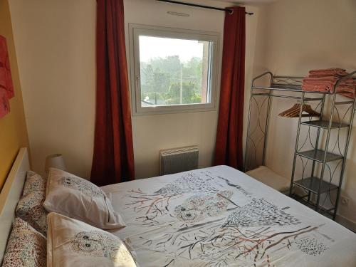 a bedroom with a bed and a window with red curtains at A l'escale fleurie in Guipavas