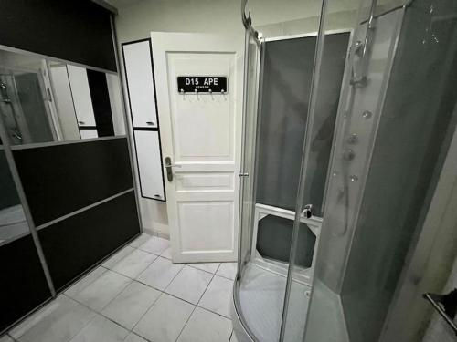 La salle de bains est pourvue d'une douche et d'un panneau sur la porte. dans l'établissement Maison 8 min plage 6 personnes, à Bompas