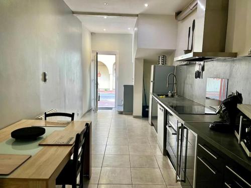 - une cuisine avec une table et un comptoir dans l'établissement Maison 8 min plage 6 personnes, à Bompas