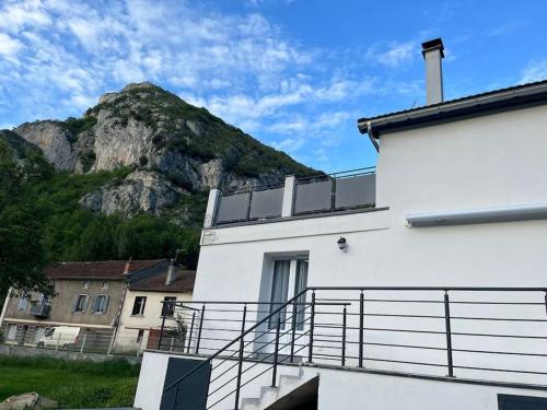 a white building with a mountain in the background at Maison vue exceptionnelle in Niaux