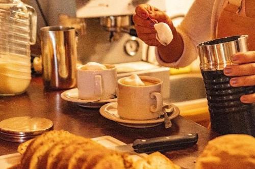 a person is making cups of coffee on a counter at cabañas Villa de las rosas in Villa de Las Rosas
