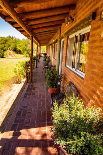 a porch of a house with benches on it at cabañas Villa de las rosas in Villa de Las Rosas
