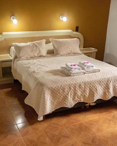 a bedroom with a bed with two towels on it at cabañas Villa de las rosas in Villa de Las Rosas