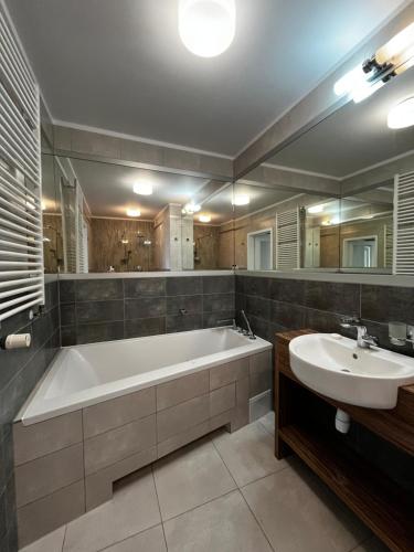 un ampio bagno con vasca e lavandino di Apartament w Baltic Cliff a Niechorze