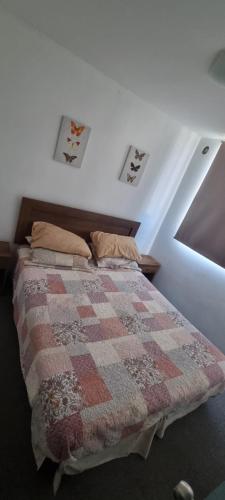 a bedroom with a bed with a quilt on it at Depto I céntrico Rdkl in Copiapó