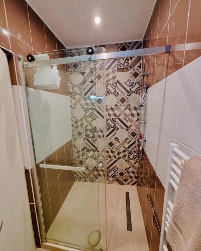a shower with a glass door in a bathroom at Le Jeanne d'Arc - Appartements meublés in Gien