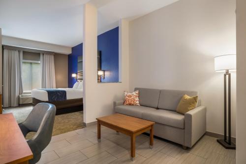 a living room with a couch and a bed at Comfort Suites Denham Springs in Denham Springs