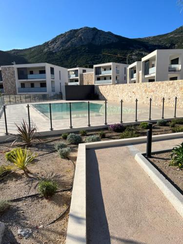 a building with a swimming pool in front of it at T2 dans une résidence neuve avec piscine in Calvi