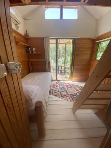 a small bedroom with a bed and a window at Kaplumbağa Bungalows in Fethiye