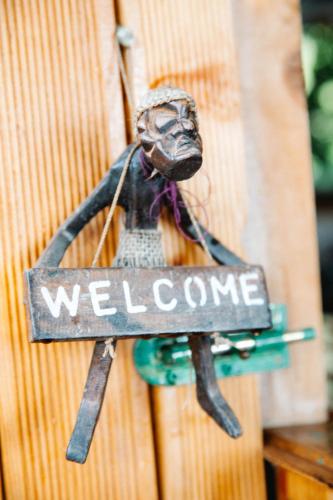 a welcome sign hanging on a wooden door at Kaplumbağa Bungalows in Fethiye