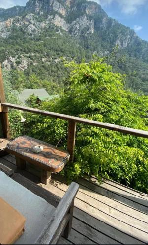a bench on a deck with a view of a mountain at Kaplumbağa Bungalows in Fethiye