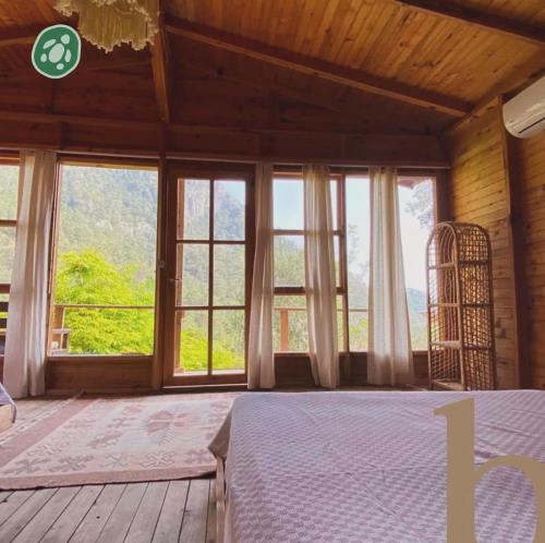 a bedroom with a bed and a large window at Kaplumbağa Bungalows in Fethiye