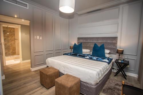 a bedroom with a large bed with blue pillows at 2 Sleeper with King Bed at Point Waterfront in Durban