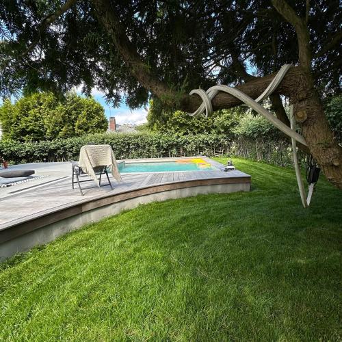 a patio with a chair next to a swimming pool at Ground floor apartment near the sea, golf, lake, and forest in Hovås