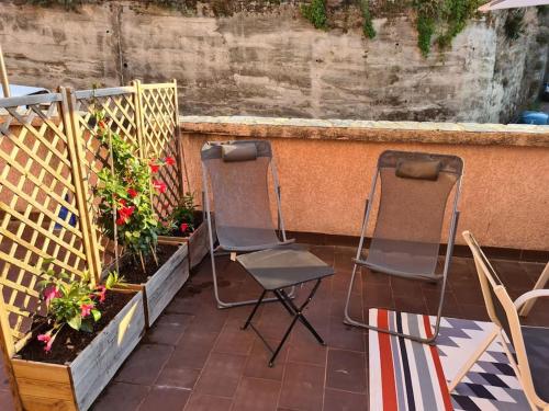 two chairs sitting on a patio with some plants at Propriano logement climatisé terrasse proche port in Propriano