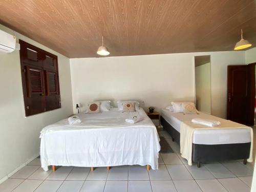 a bedroom with two beds with white sheets at Pousada Sitio Parque dos Lençóis in Barreirinhas