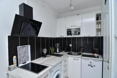 a white kitchen with a sink and a dishwasher at La splendida in Becici