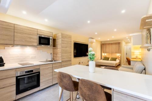 een keuken en een woonkamer met een tafel en stoelen bij La Cigale Varoise - Hyères La Plage in Hyères