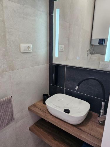 a bathroom with a white sink and a mirror at Cassiopeia - Seaside Retreat in Omišalj