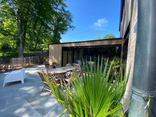 a patio with a table and chairs next to a building at Gîte de la Tour in Hotton