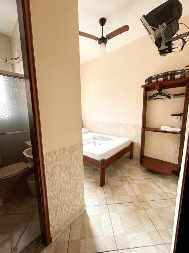 a room with a bed and a ceiling fan at Pousada Santa Rosa in Aparecida