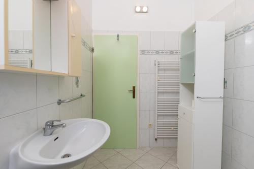 a white bathroom with a sink and a shower at HAUS RITA in Labin