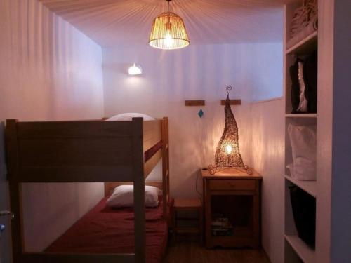 Cette petite chambre comprend des lits superposés et une lampe. dans l'établissement Appart 6 pers avec piscine, à Allos