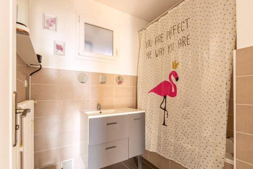 - une salle de bains avec une étiquette flamande rose sur le mur dans l'établissement Joli appartement cosy, à Valence