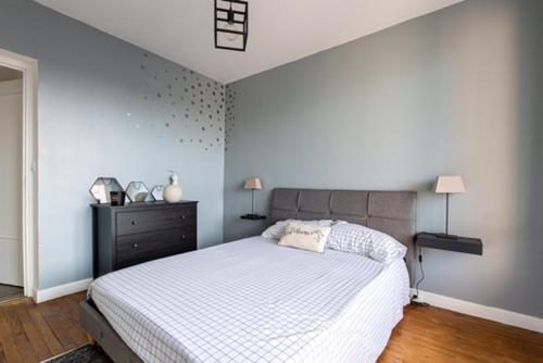 - une chambre avec un lit blanc et une commode noire dans l'établissement Joli appartement cosy, à Valence