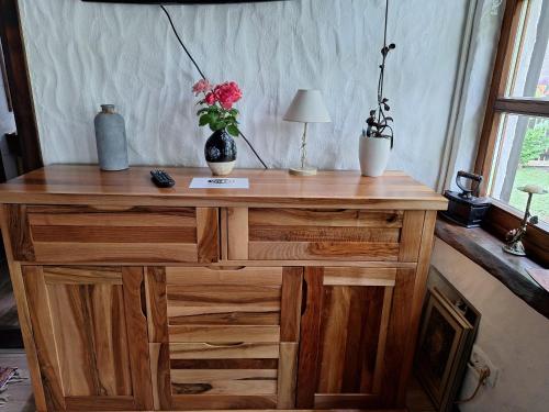 a wooden desk with a vase of flowers on it at ATRIUM Holiday home in Bihać