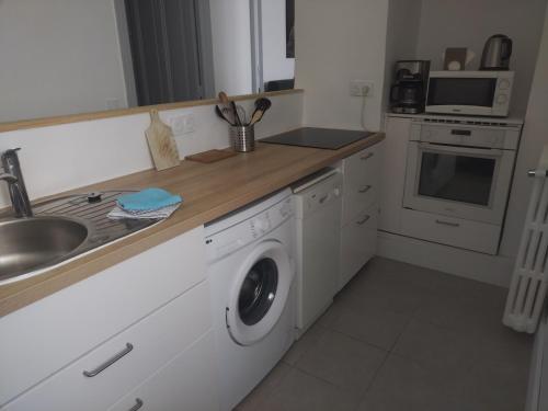 a kitchen with a sink and a washing machine at LaResidence in Saint-Gervais-les-Bains