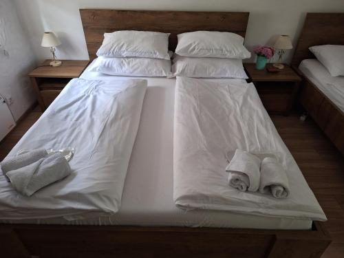 a large bed with white sheets and towels on it at ATRIUM Holiday home in Bihać