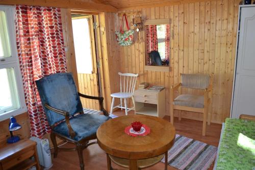 a living room with a chair and a table at Västersten Sipoo in Sipoo