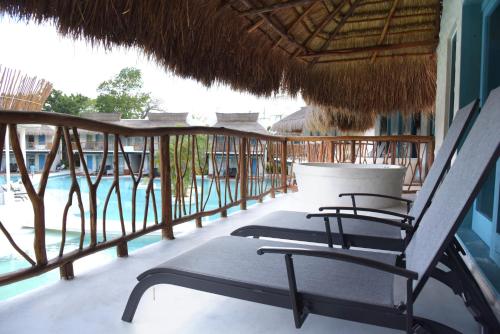 a balcony with chairs and a swimming pool at Hacienda Susulá in Susulá