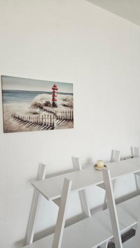 a white table and chairs with a picture of a lighthouse at M&M Bazen resort Goražde in Goražde