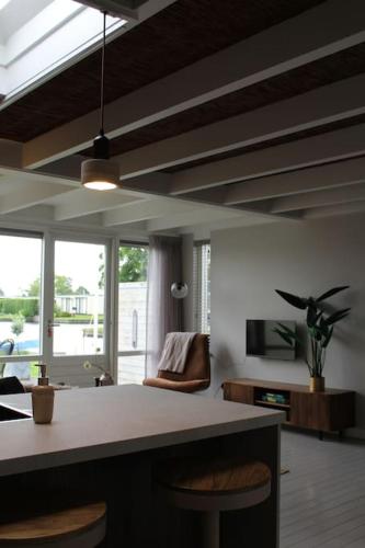 a kitchen with a counter and chairs in a room at NIEUW Bootique Frysk huske Langweerderwielen in Boornzwaag