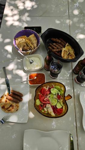 a table with plates of food on a table at M&M Bazen resort Goražde in Goražde