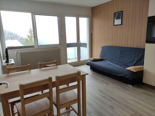 un salon avec un lit, une table et des chaises dans l'établissement Appartement avec joli point de vue, à Eaux-Bonnes