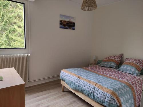 une chambre avec un lit et une fenêtre dans l'établissement Appartement avec joli point de vue, à Eaux-Bonnes