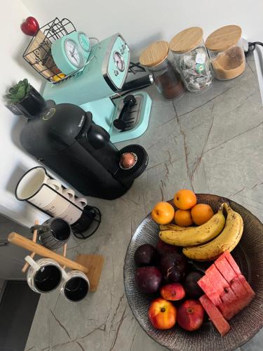 - un bol de fruits sur un comptoir avec une assiette de fruits dans l'établissement Fati appart, à Sannois