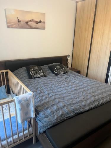 - une chambre avec un lit bébé et un lit avec des oreillers dans l'établissement Fati appart, à Sannois