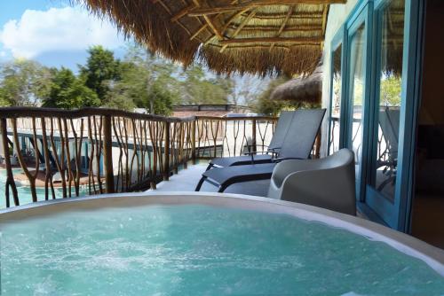 a hot tub on a porch with chairs and a patio at Hacienda Susulá in Susulá