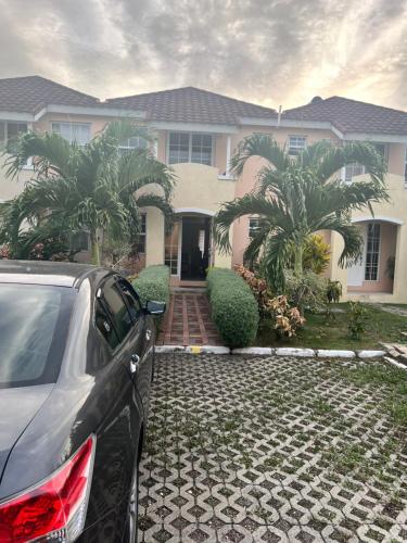 a car parked in front of a house at Comfort Rest in Ocho Rios