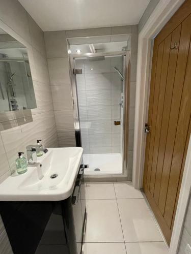 a white bathroom with a sink and a shower at Guest Room with Parking Near St Ives & Penzance in Penzance
